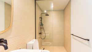 a bathroom with a shower with a toilet and a sink at Modern and comfortable apartment in Pointe aux Cannoniers
