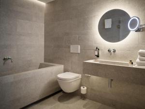 a bathroom with a toilet and a sink and a mirror at Hotel 1904 in Ålesund