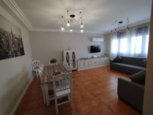 un soggiorno con un tavolo e un divano di El Balcon a Toledo a 5 minutos del puy du fou a Cobisa