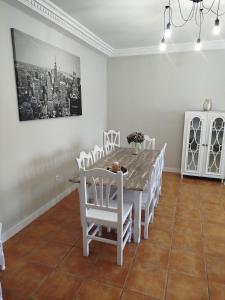 una sala da pranzo con un tavolo e sedie bianche di El Balcon a Toledo a 5 minutos del puy du fou a Cobisa