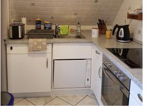 a kitchen with a sink and a counter top at Adlerhorst - Moderne 60 qm Wohnung mit Terrasse in Oevenum +3 photos