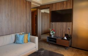 a living room with a couch and a flat screen tv at Villa Blanca Urban Hotel in Casablanca