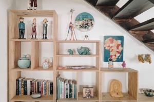 a wooden book shelf with books and figurines at Gonana Guesthouse in Paternoster