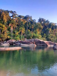 un grande bacino d’acqua con alberi sullo sfondo di Suíte Capiá a Ubatuba