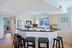 a kitchen with a bar with stools in it at SG3C: 3C Seagrove Villa in Isle of Palms