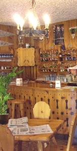 un restaurante con mesa y un bar con botellas de vino en Sporting Hotel Club, en Pelos