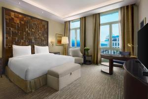 a hotel room with a large bed and a desk at Kempinski Palace Cairo in Cairo