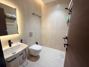a bathroom with a white toilet and a sink at Luxury Apartment شقه الفخامه في المونسيه in Riyadh