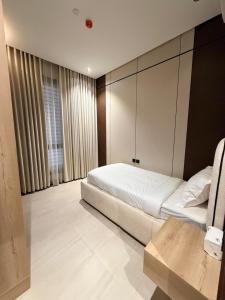 a bedroom with a white bed and a cabinet at Luxury Apartment شقه الفخامه في المونسيه in Riyadh