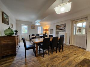 une salle à manger avec une table et des chaises noires dans l'établissement Gites de groupes Les Muriers, à Bourgvilain 16 autres photos
