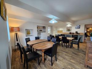 une salle à manger avec tables et chaises et une cuisine dans l'établissement Gites de groupes Les Muriers, à Bourgvilain