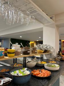 a buffet with many plates of food on a counter at Alma Candida 11 in Valença +16 photos