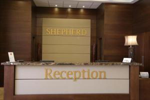 un mostrador de recepción en el vestíbulo de un hotel con una señal de registro del hotel en Shepherd Hotel, en Bethlehem