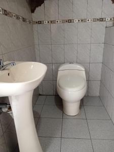 a bathroom with a toilet and a sink at Huilka Mayu in Urubamba +14 photos
