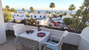 Una mesa y sillas en un balcón con vista al mar. en Vv Apartamento Gran Vista Los Marinos, en Tías