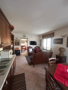 a kitchen and a living room with a couch at Casa Belvedere in Lizzano in Belvedere