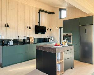 a kitchen with green cabinets and a counter top at Stylish Mountain Cabin In Hallingdalen in Flå