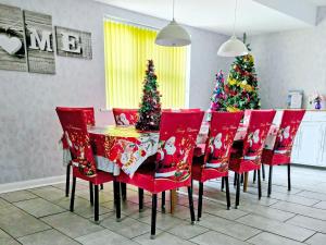 ein Esszimmer mit roten Stühlen und Weihnachtsbäumen in der Unterkunft The Paddock in Cumberworth + 23 Fotos