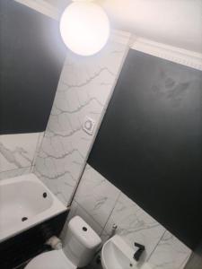 a bathroom with a white toilet and a sink at Beach Vibes Villa in Cape Town