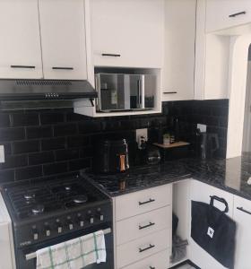 a kitchen with a stove and a microwave at Beach Vibes Villa in Cape Town