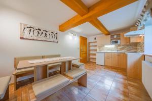 a kitchen with a table and a bench in it at Apartmány Koloniál in Rokytnice nad Jizerou +18 photos