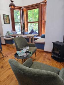 a living room with chairs and a table and a stove at Under the Maple in Rawsonville