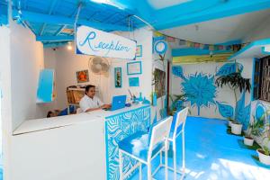 Viik wellness inn -3 Star Resort in Arambol Beach في أرامبول: رجل يجلس في مكتب مع الكمبيوتر المحمول +152 صورة