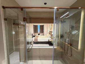 een badkamer met een douche en een bed in een kamer bij De Lush Pune in Pune