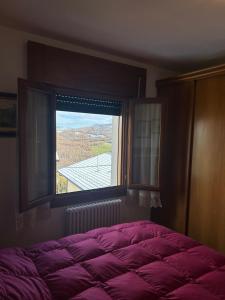 a bedroom with a large bed and a window at Casa Belvedere in Lizzano in Belvedere