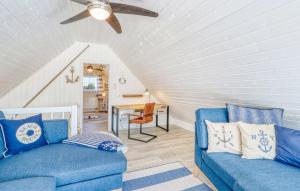 a living room with two blue couches and a ceiling fan at Haus Ankerplatz in Wandlitz