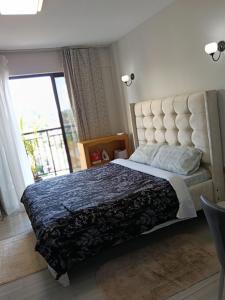 a bedroom with a large bed with a large window at Quick Connect Studio Kileleshwa in Nairobi