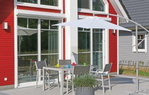 - une table et des chaises avec un parasol en face d'une maison dans l'établissement Haus Patricia, à Wandlitz