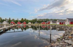 un groupe de maisons sur un lac avec réflexion dans l'eau dans l'établissement Haus Patricia, à Wandlitz