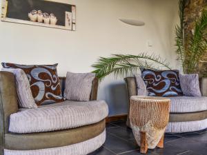 Honeysuckle Cottage في High Bickington: غرفة معيشة مع كرسيين وطاولة