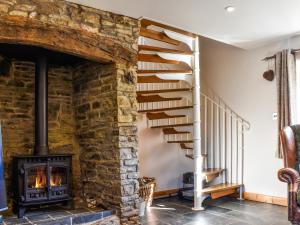 Honeysuckle Cottage في High Bickington: درج حجري في غرفة المعيشة مع مدفأة