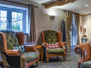 Honeysuckle Cottage في High Bickington: غرفة معيشة مع كرسيين ونافذة