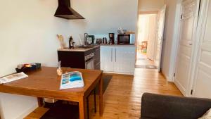 a living room with a wooden table and a kitchen at Villa la Korrigane vue mer cuisine privée in Étables-sur-Mer