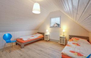Schlafzimmer im Dachgeschoss mit 2 Betten und einem blauen Stuhl in der Unterkunft Ferienhaus Hafenoase in Wandlitz