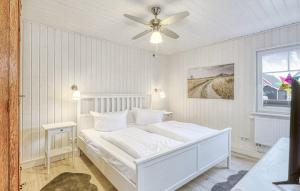 una camera da letto bianca con un letto e un ventilatore a soffitto di Villa Kunterbunt a Wandlitz Altre 9 foto