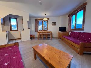 a living room with a couch and a table at Résidence Saboia Clés Blanches in La Tania