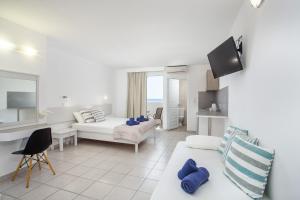 un soggiorno bianco con un divano e un tavolo di Anika Studios Faliraki a Faliraki