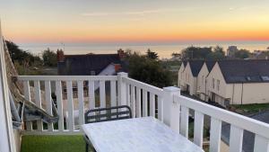 a white balcony with a table and a view at Villa la Korrigane vue mer cuisine privée in Étables-sur-Mer