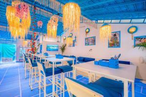 Viik wellness inn -3 Star Resort in Arambol Beach في أرامبول: مطعم به طاولات وكراسي وثريات