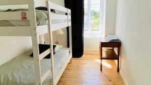 a room with two bunk beds and a table at Villa la Korrigane vue mer cuisine privée in Étables-sur-Mer