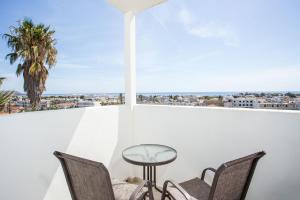 un balcone con sedie, tavolo e palma di Anika Studios Faliraki a Faliraki