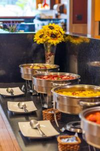 a buffet line with bowls of food and a vase of flowers at Gran Villagio Hotel SP by Castelo Itaipava in Sao Paulo +57 photos