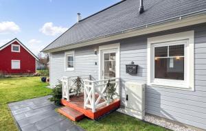 een grijs huis met een veranda en een rode schuur bij Haus Charlotte in Wandlitz