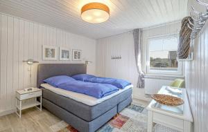 una camera da letto con un letto blu e una finestra di Lavendel-Lodge a Wandlitz