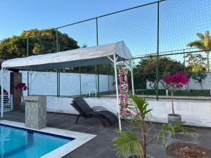 een paviljoen met een bankje naast een zwembad bij casa de campo em Aldeia PE in Recife