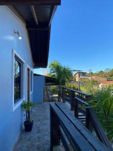 Un balcón de una casa con un banco de madera en Pousada Mizuyama, en Praia do Rosa